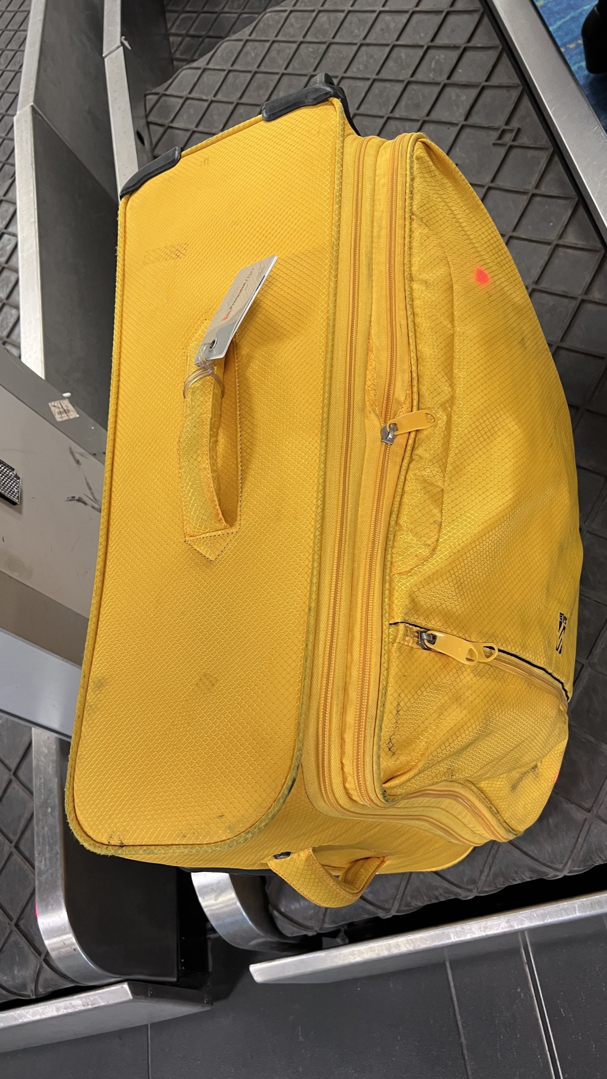 Yellow suitcase on baggage belt
